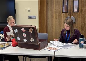 Two librarians look through the resources in the Kindness Suitcase
